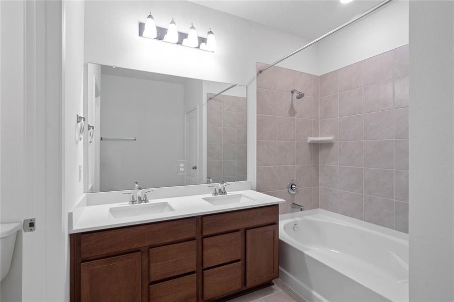 This primary bathroom is definitely move-in ready! Featuring an oversized tub/shower combo with tile surround, stained cabinets with light countertops, high ceilings, neutral paint, sleek and modern finishes.