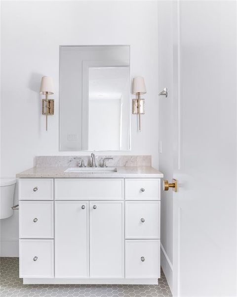 Bathroom with vanity, toilet, and tile patterned flooring