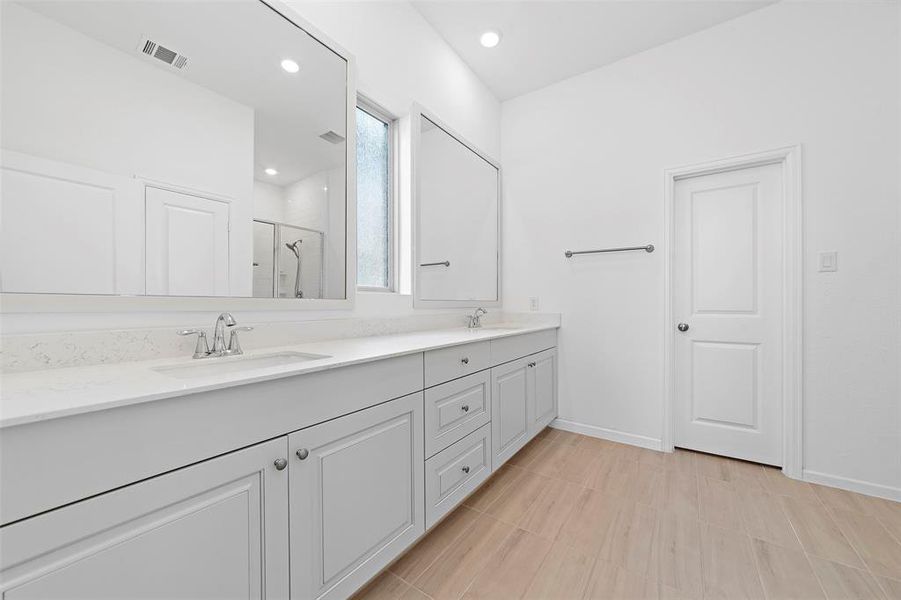Master bathroom with double sinks and large walk-in shower. That door opens into the large master closet which feeds right into the laundry room.  How convenient!