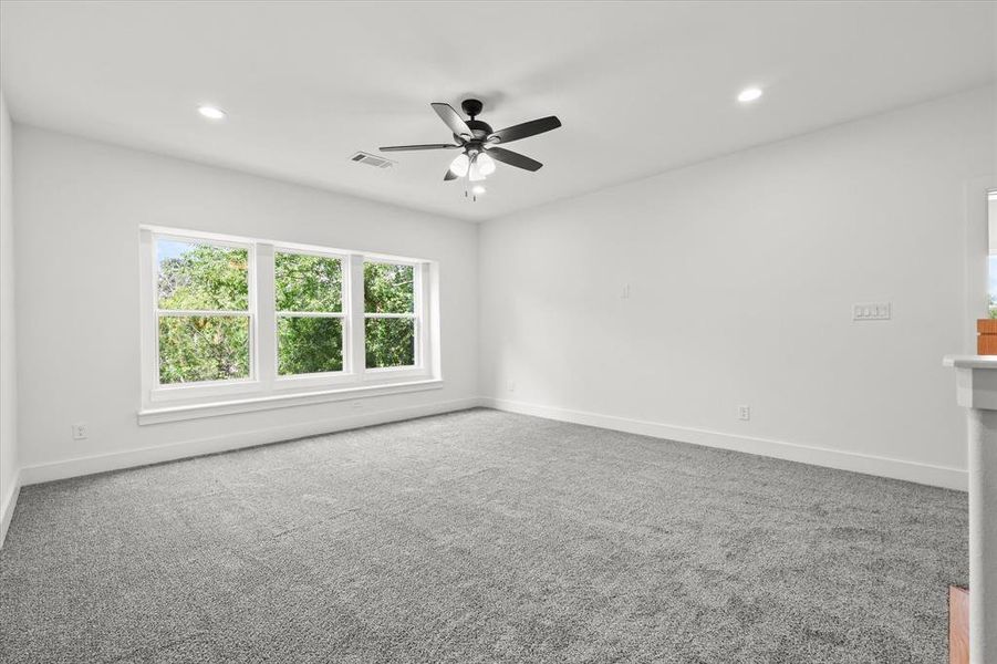 Carpeted empty room featuring ceiling fan