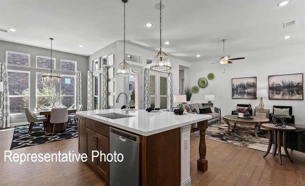 Kitchen featuring dishwasher, dark hardwood / wood-style flooring, hanging light fixtures, and sink