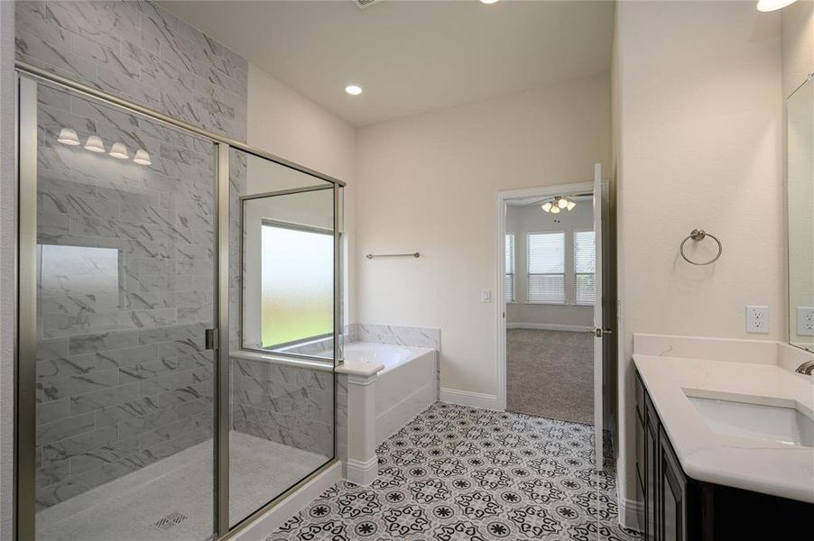 Bathroom featuring tile patterned flooring, plus walk in shower, and vanity