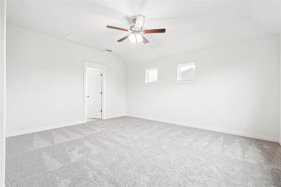 Spare room with lofted ceiling, carpet floors, and ceiling fan