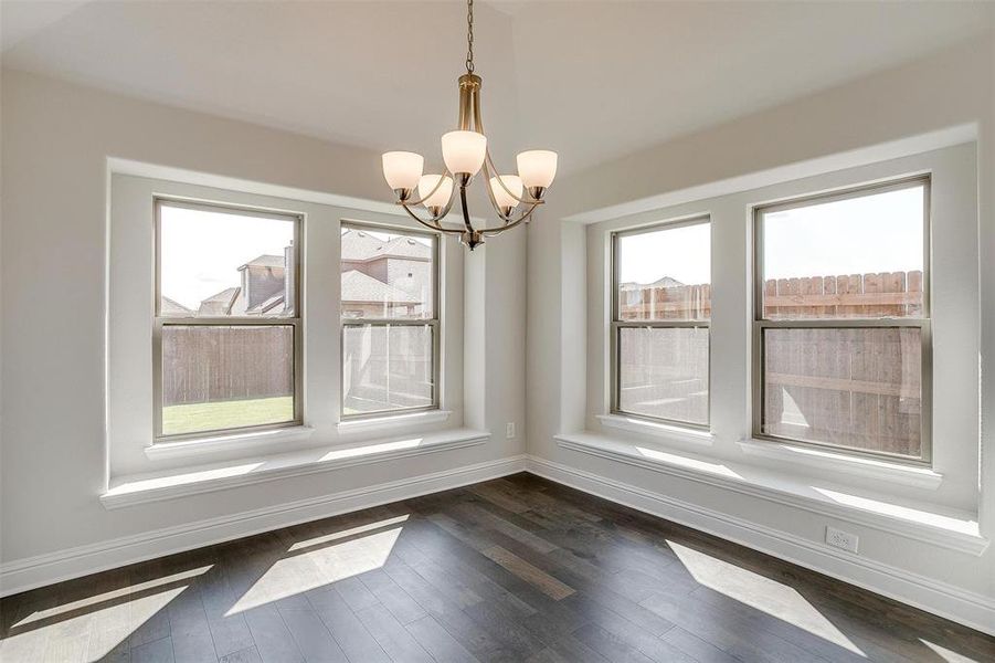 Unfurnished dining area featuring dark hardwood / wood-style floors and a chandelier