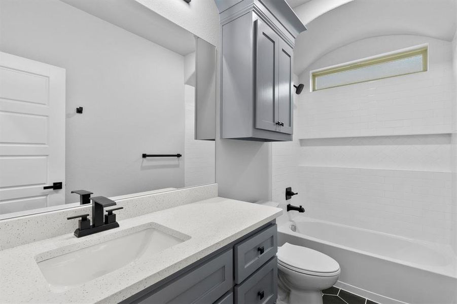 Full bathroom featuring toilet, shower / washtub combination, vanity, and tile patterned flooring