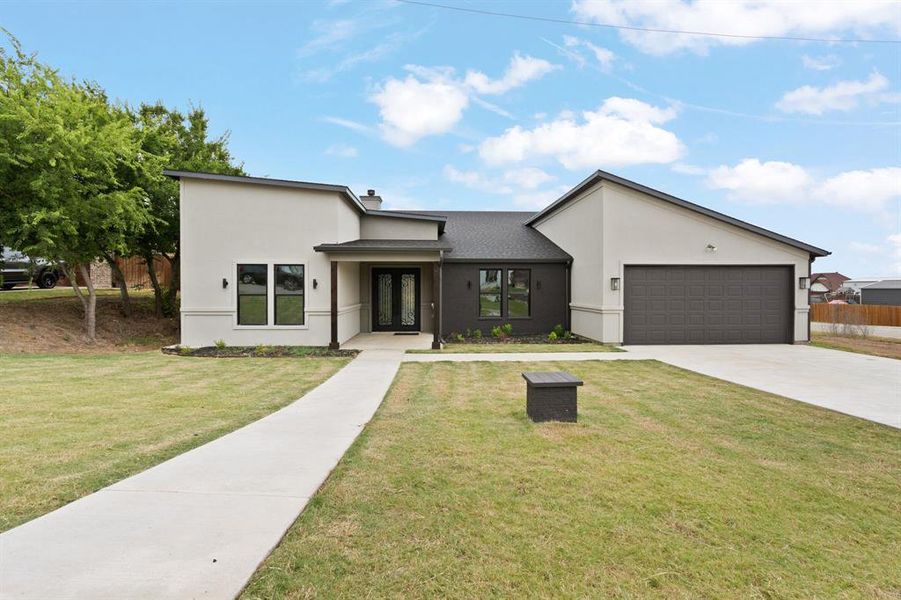 View of front of home featuring a garage and a front yard