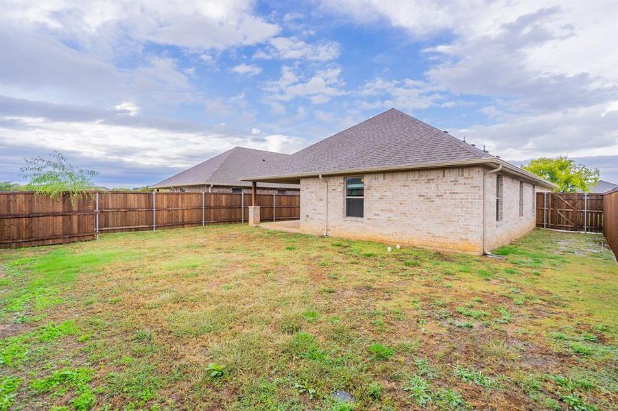 Rear view of property with a patio and a yard