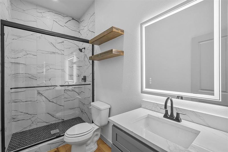 Bathroom with vanity, toilet, hardwood / wood-style flooring, and walk in shower