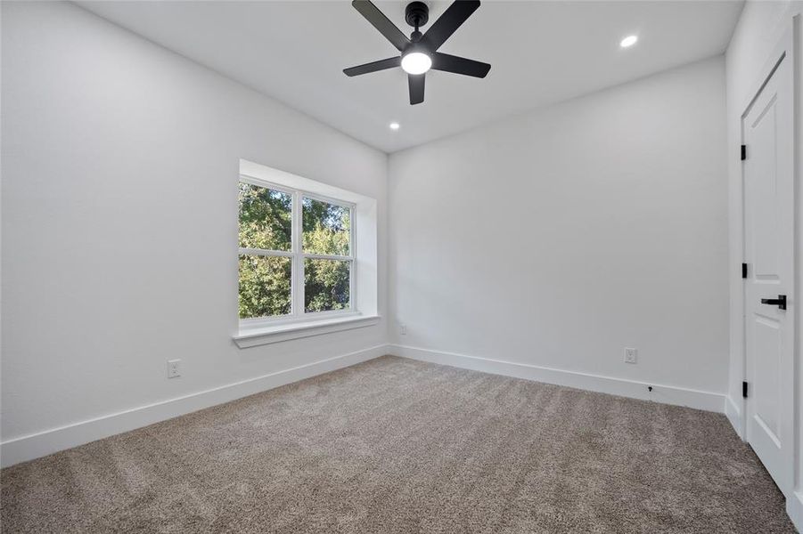 Carpeted spare room with ceiling fan