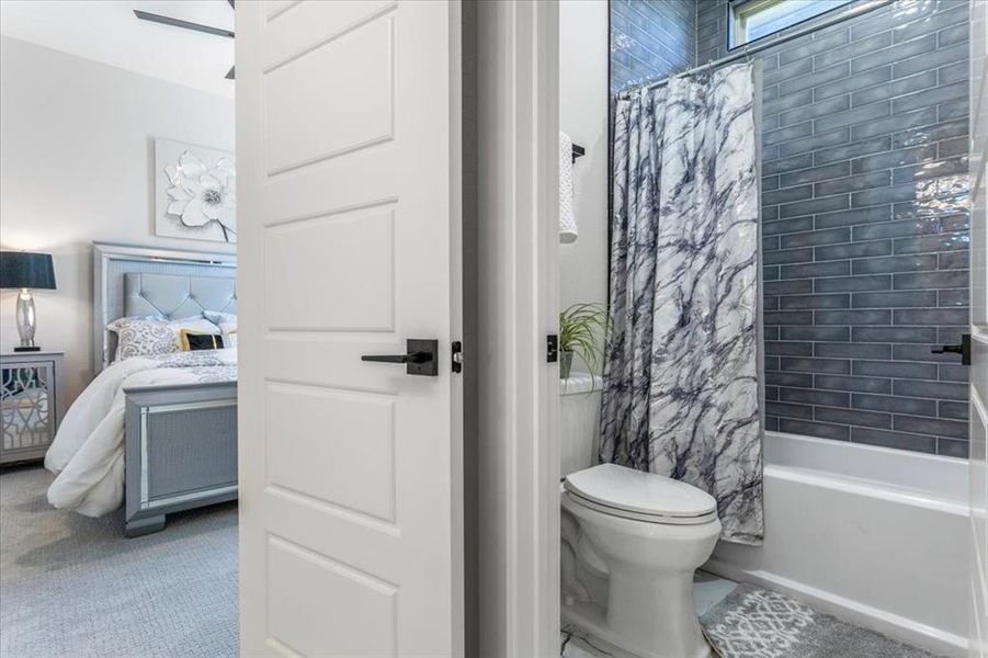 Full bathroom with shower / bath combination with curtain, vanity, and toilet