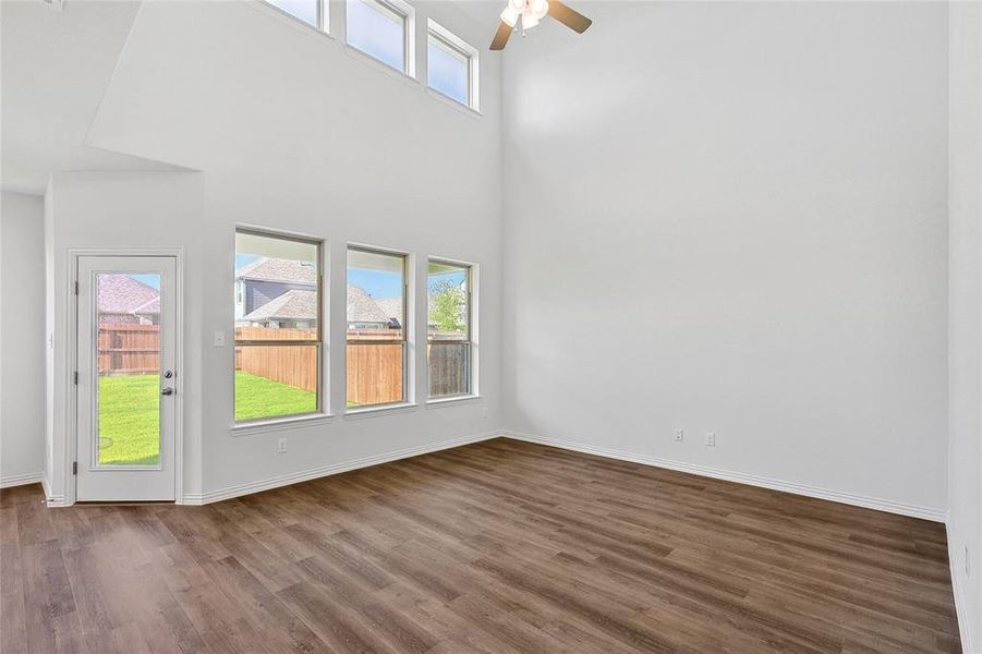 Spare room with a high ceiling, ceiling fan, and dark hardwood / wood-style flooring