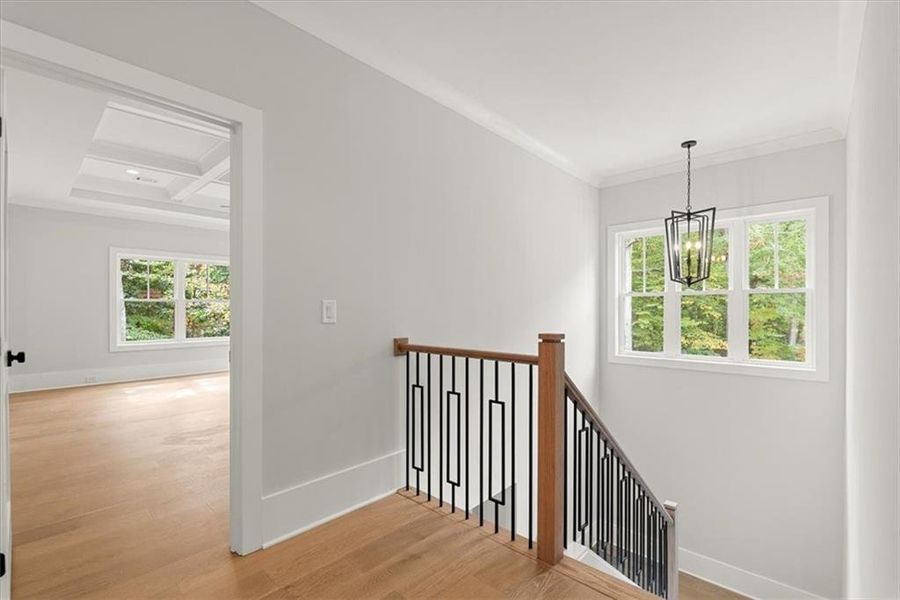 Stairs with light hardwood / wood-style flooring, a chandelier, crown molding, coffered ceiling, and beam ceiling