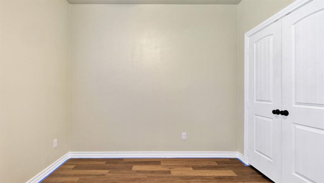 Unfurnished bedroom with dark hardwood / wood-style flooring