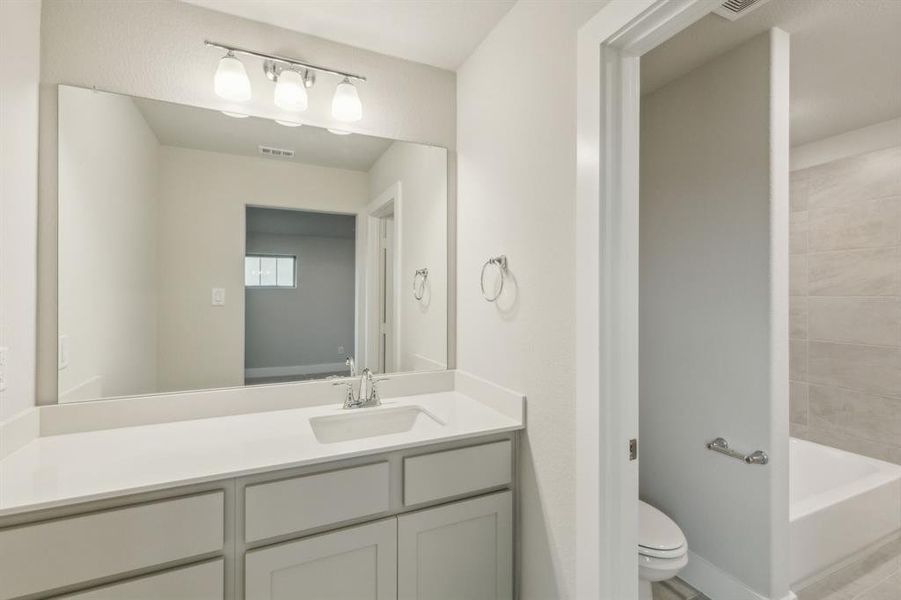 Bathroom with vanity, toilet, and a tub