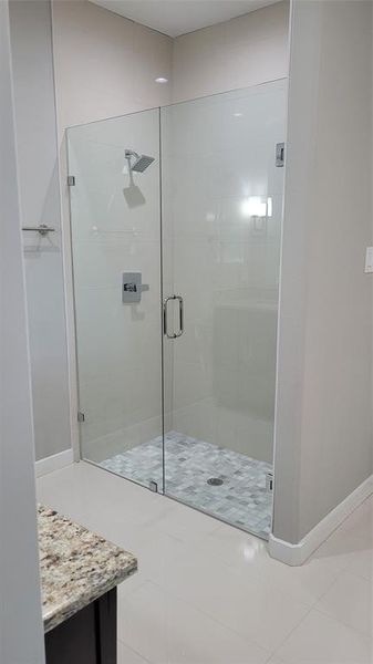 Bathroom featuring vanity, tile patterned flooring, and an enclosed shower
