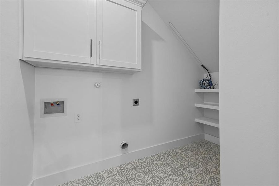 Laundry area featuring hookup for an electric dryer, washer hookup, and light tile patterned floors