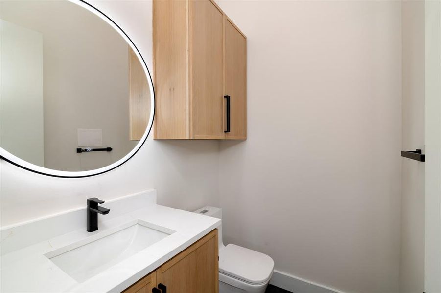 Bathroom with vanity with extensive cabinet space and toilet