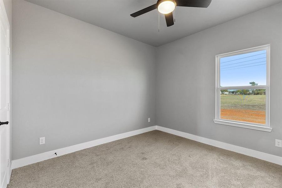 Carpeted empty room with ceiling fan