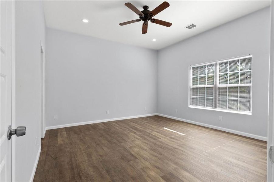 Empty room with wood-type flooring and ceiling fan