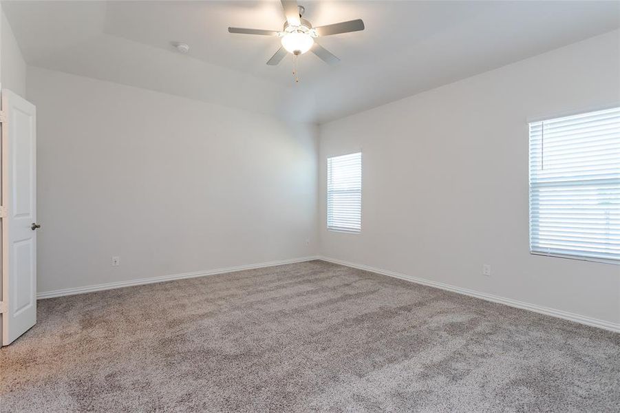 Carpeted empty room with ceiling fan