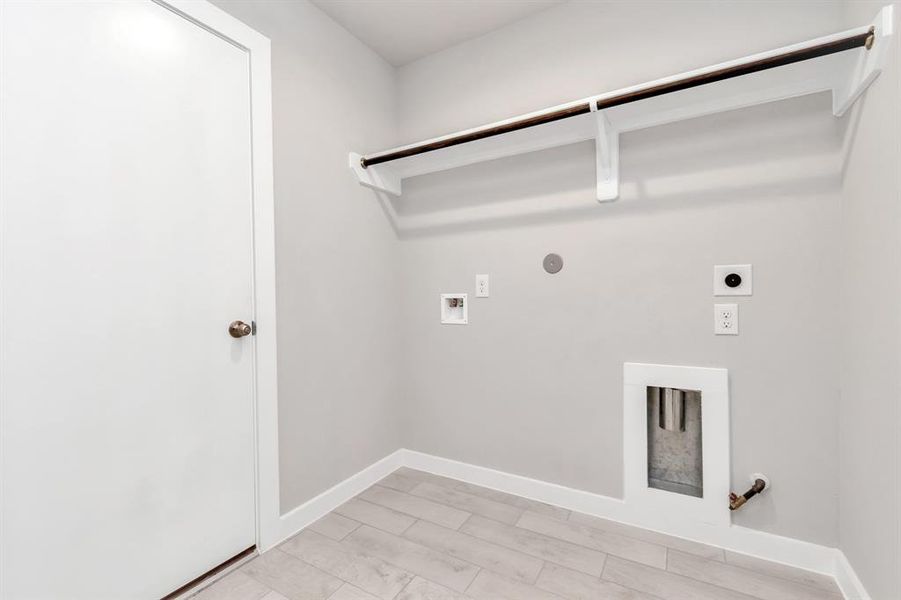 A perfect blend of functionality and comfort. Laundry room, thoughtfully equipped with shelving for effortless organization. Both gas and electric connections available. Sample photo of completed home with similar floor plan. As-built interior colors and selections may vary.