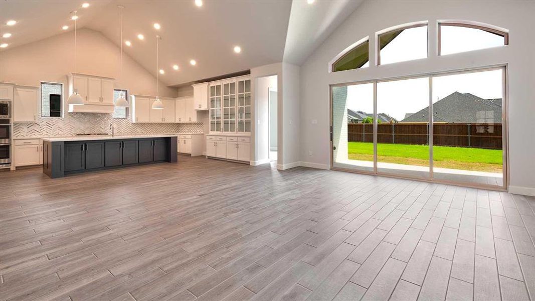 Unfurnished living room featuring high vaulted ceiling and light wood-type flooring