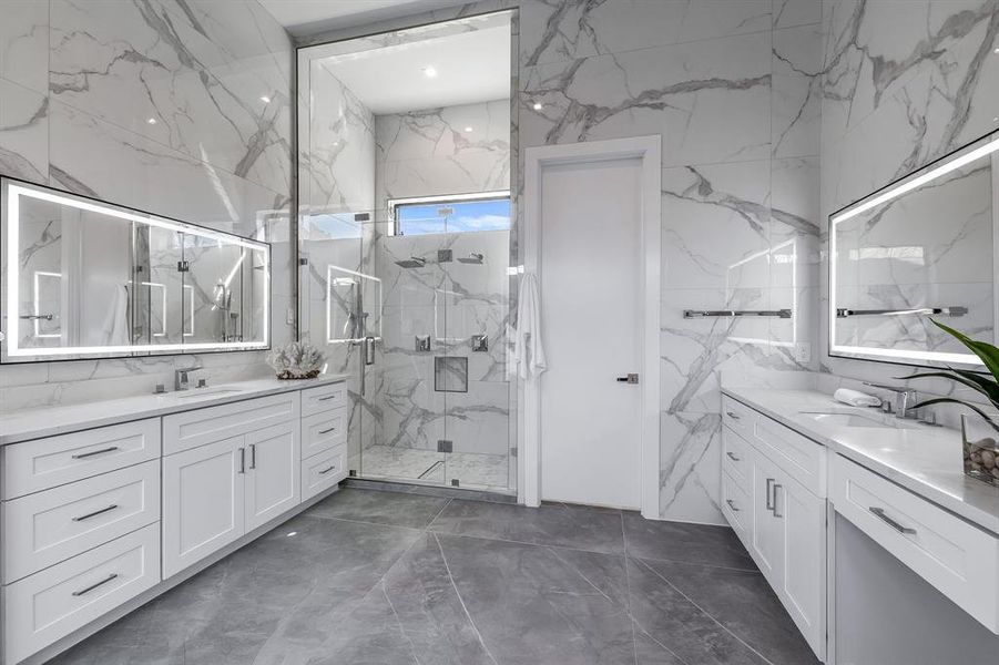 Bathroom featuring vanity, tile walls, and walk in shower