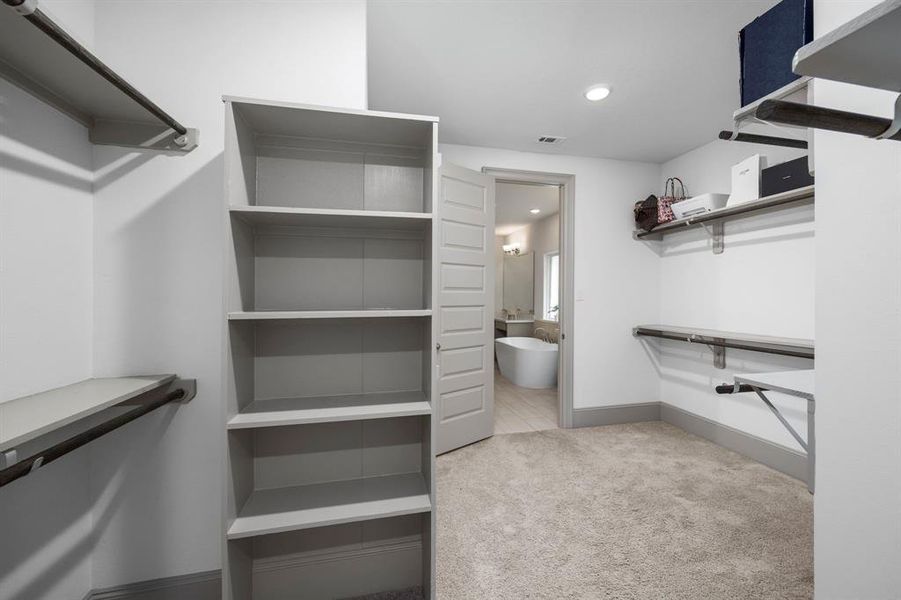 Large primary bedroom closet connects to the en-suite bath and the laundry room.