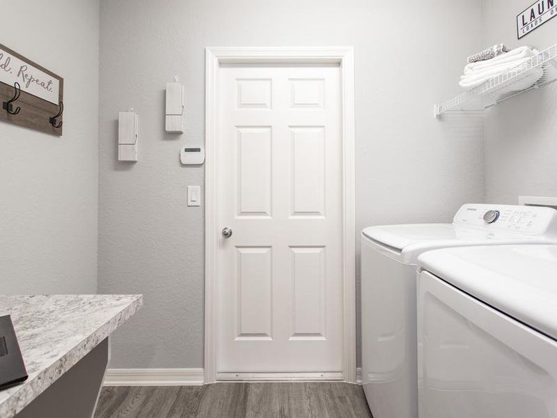 Laundry room with convenient drop zone, at the garage entry - Peyton home plan by Highland Homes