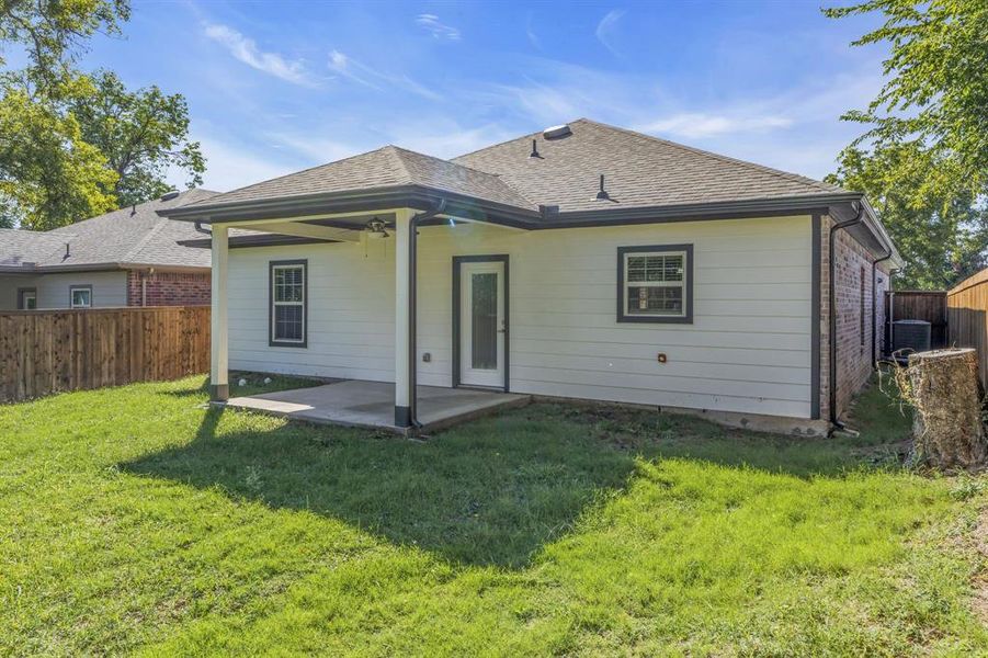 Rear view of house with a patio and a yard