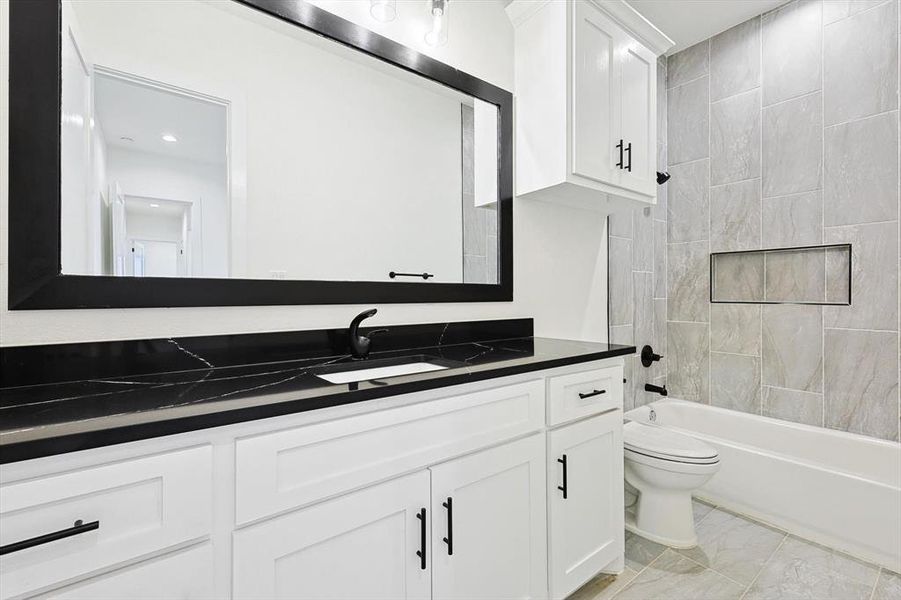 Full bathroom featuring vanity, toilet, and tiled shower / bath