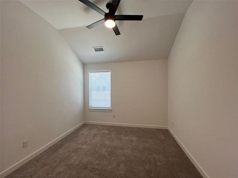 Unfurnished room with lofted ceiling, ceiling fan, and carpet flooring