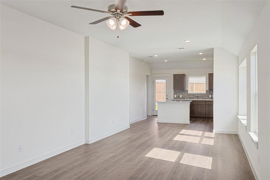 Unfurnished living room with sink, light wood-type flooring, and ceiling fan