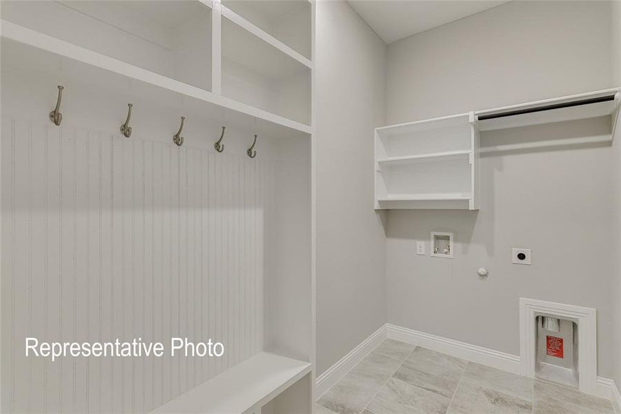 Clothes washing area featuring hookup for an electric dryer, washer hookup, gas dryer hookup, and light tile patterned flooring