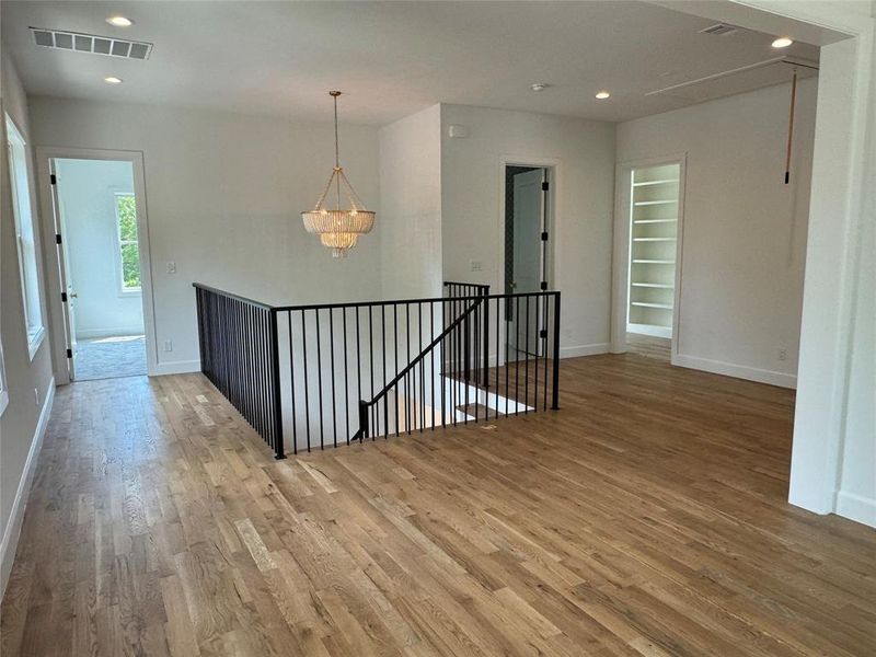 Spare room featuring hardwood / wood-style flooring and a notable chandelier