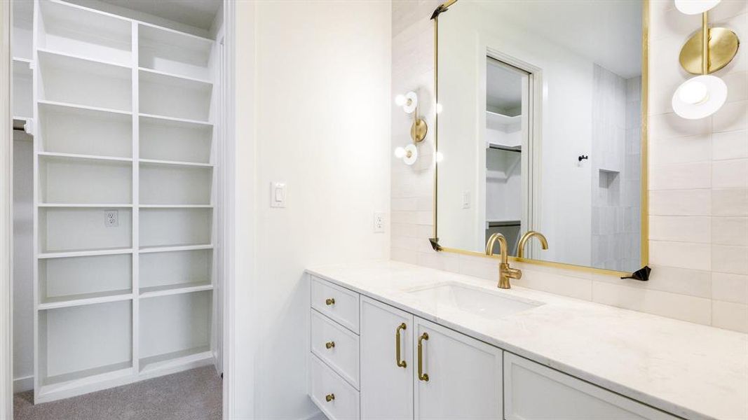 Bathroom with vanity and tasteful backsplash