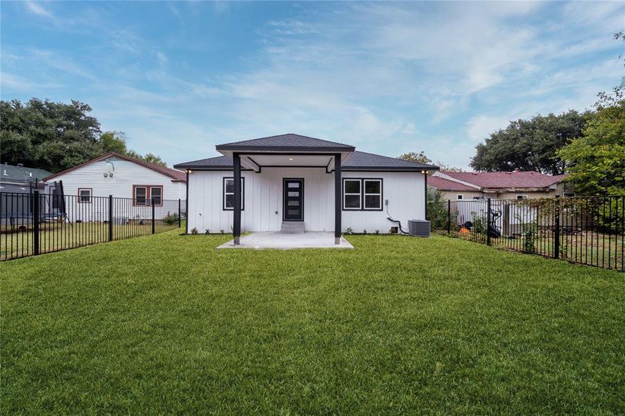 Back of property featuring central air condition unit and a lawn once it grows