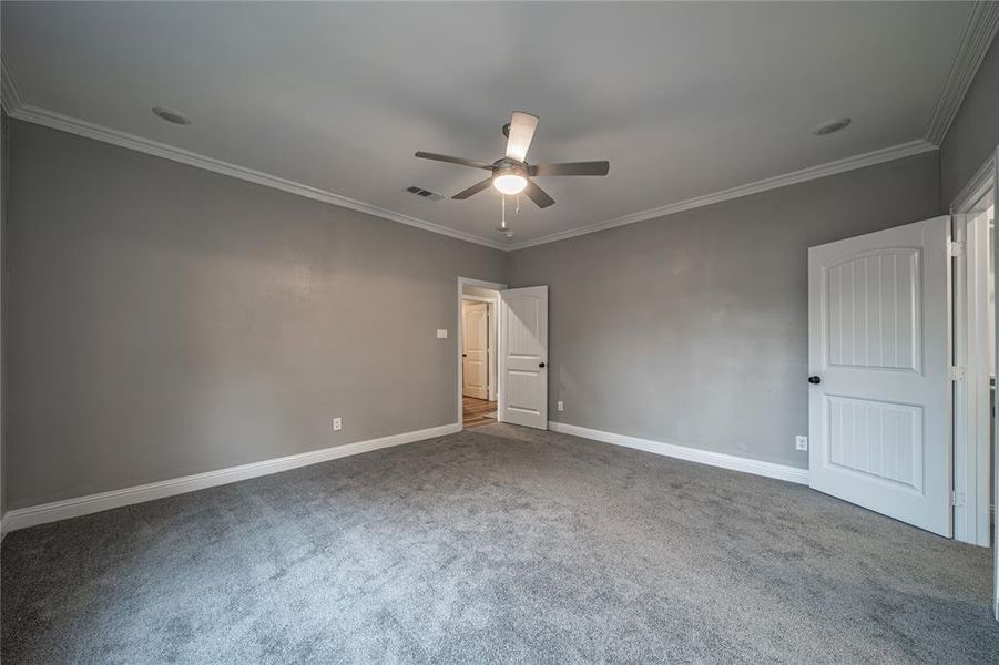 Unfurnished bedroom with ornamental molding, carpet floors, and ceiling fan