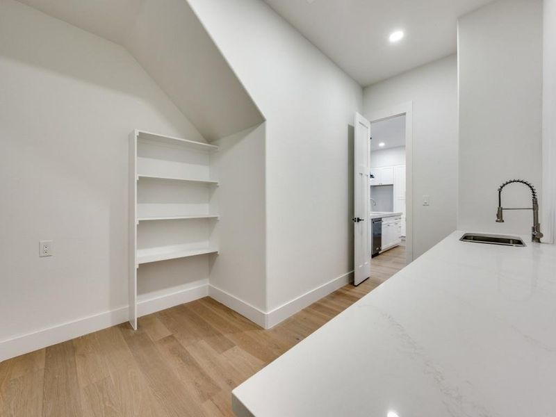 Bedroom featuring sink and light wood-type flooring