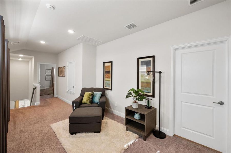 Sitting room with lofted ceiling and light colored carpet