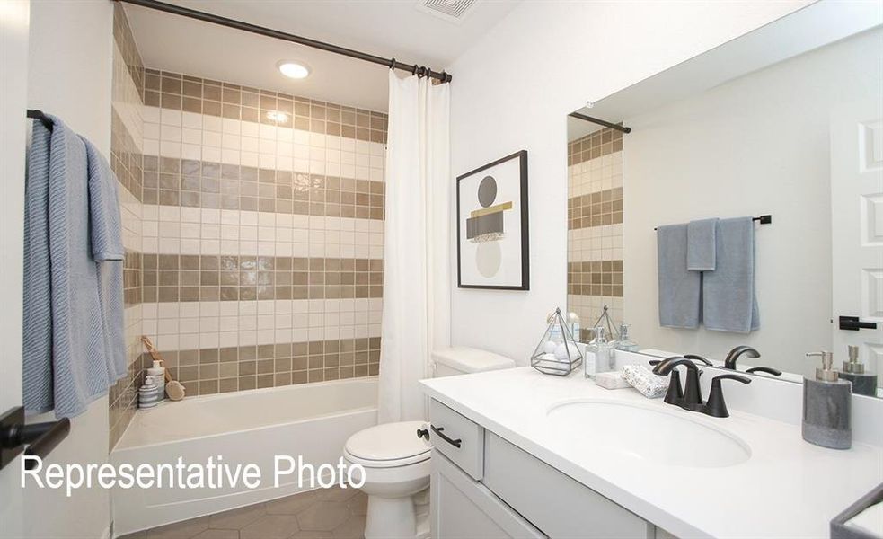 Full bathroom featuring tile patterned flooring, vanity, toilet, and shower / bath combination with curtain