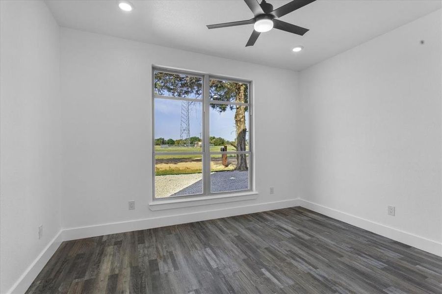 Empty room featuring dark hardwood / wood-style floors and ceiling fan