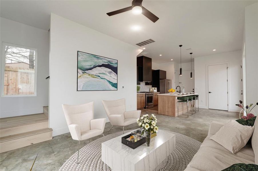 Living room facing staircase and kitchen. Virtually staged photo.