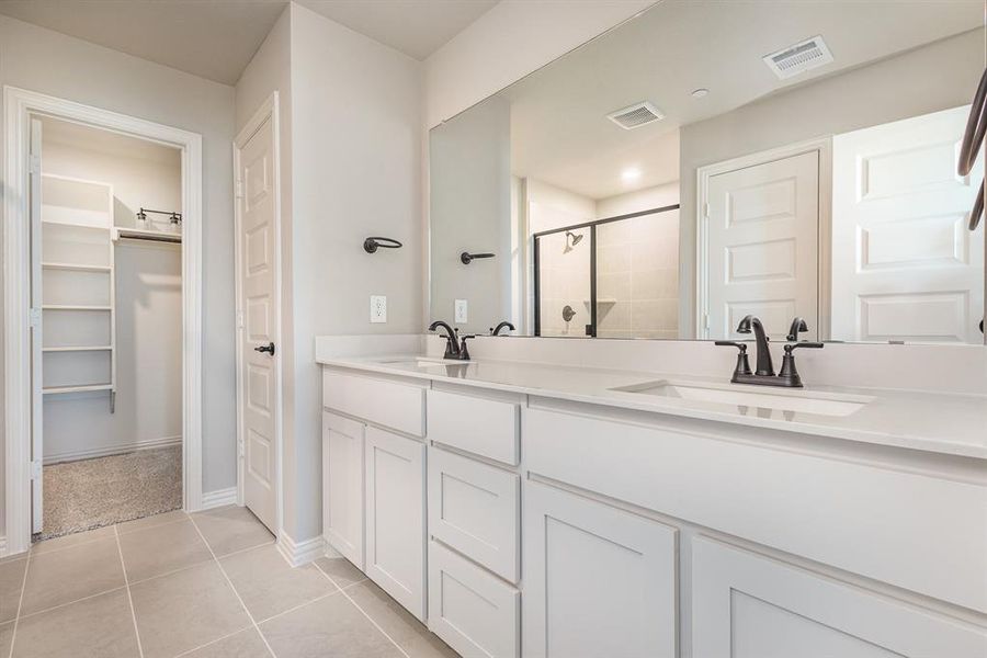 Bathroom with vanity, an enclosed shower, and tile patterned floors