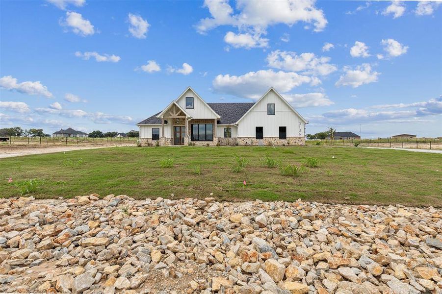 View of front facade featuring a porch and a rural view