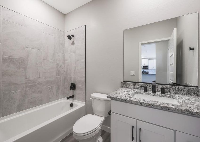 Secondary bathroom with a dual shower and tub, lined with tile.