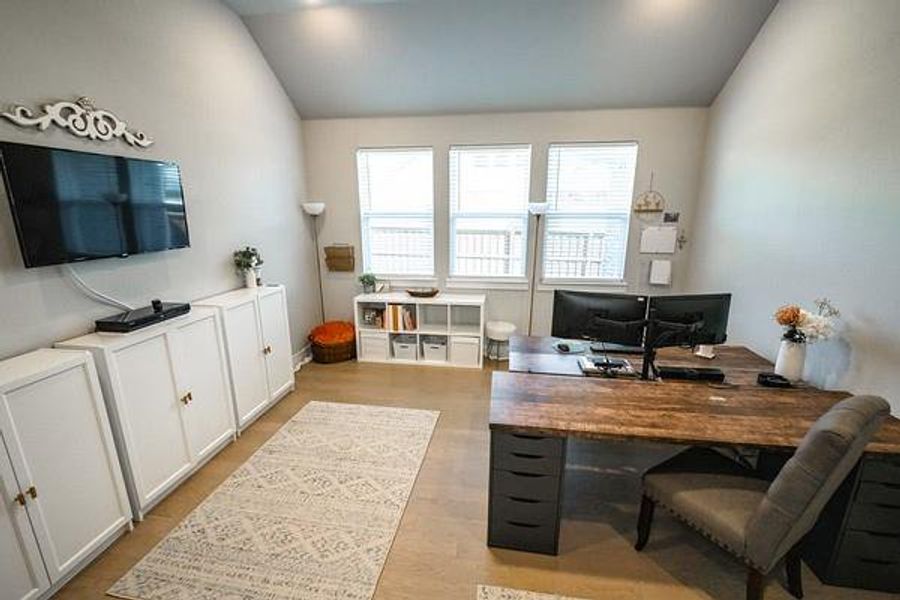 Home office featuring light hardwood / wood-style floors and vaulted ceiling