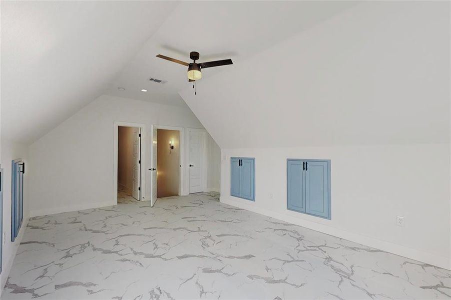 Bonus room with light tile patterned flooring, lofted ceiling, and ceiling fan