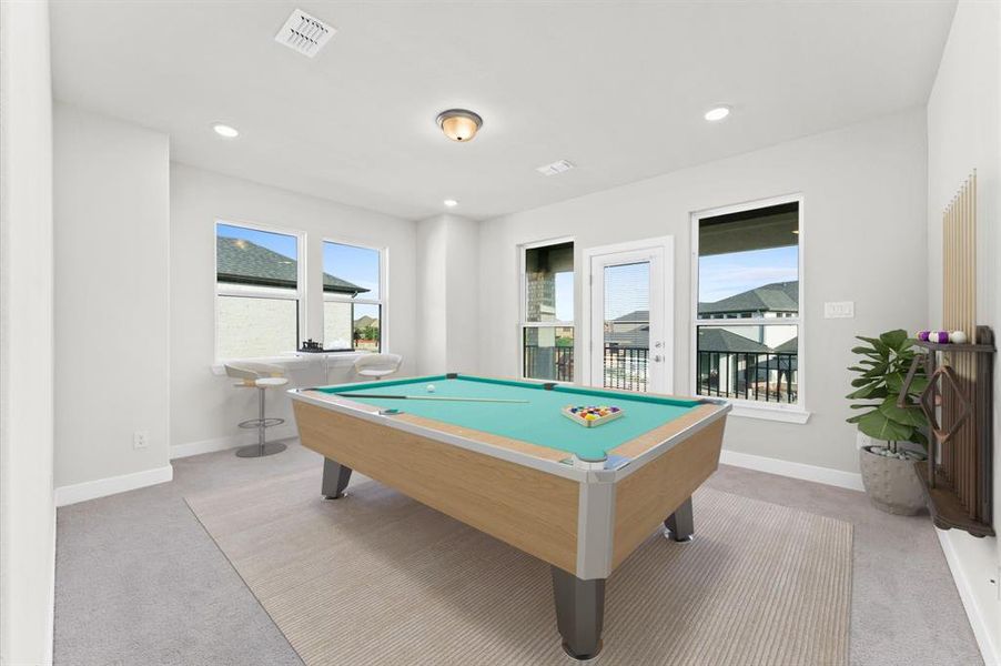 The game room in this Avalon Riverstone home is designed for fun and relaxation, with easy access to the balcony for fresh air and stunning views.