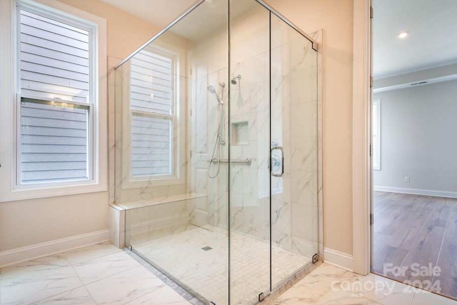 You'll never want to leave this "spa-like"  zero-entry Shower w/beautiful tiled floors & walls as well as frameless shower door. Handheld shower & grab bar for extra comfort and safety.